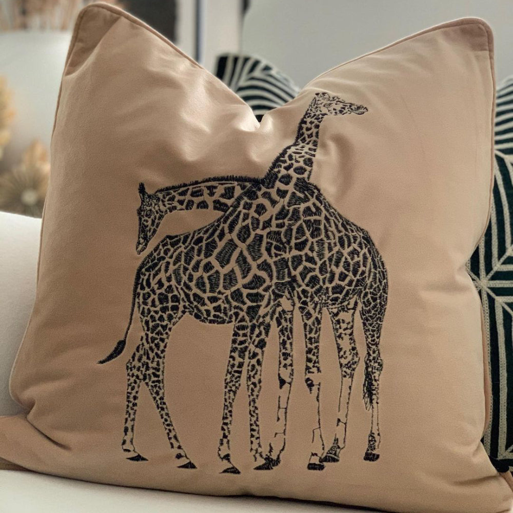 Beige prydnadkudde med motivet av broderad giraff